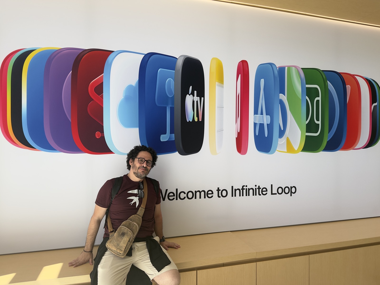 Ezequiel at Apple Infinite Loop beneath a wall of colorful app icons